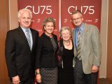 Erica Cherney poses for a picture with members of her family in front of a CU75 backdrop