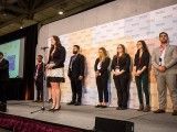 A team member from the Sprott School of Business describes their project on stage.