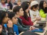 Several young women listen to a presentation during the Technovation Challenge.