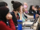A young woman listens to a presentation during the Technovation Challenge.