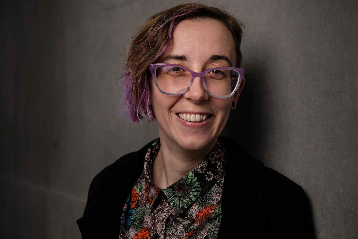 A headshot of a woman with short hair and glasses, smiling for the camera.