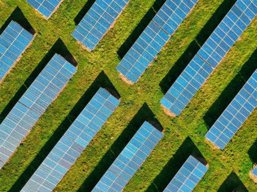 An aerial view of solar panels in a large field.
