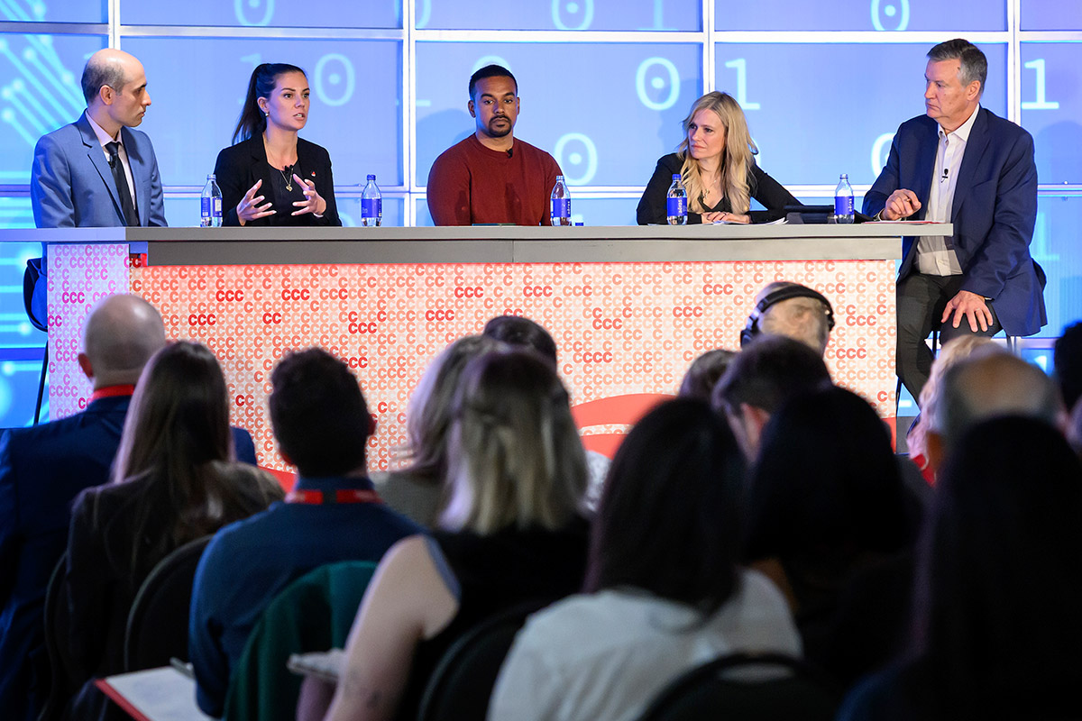 Five people sitting on a discussion panel at an event.