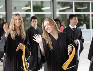Students wave as they enter Alumni Hall for convocation.