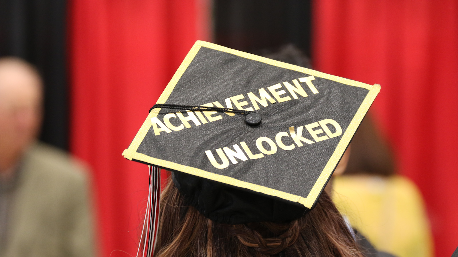A graduate's cap reads "Achievement Unlocked"