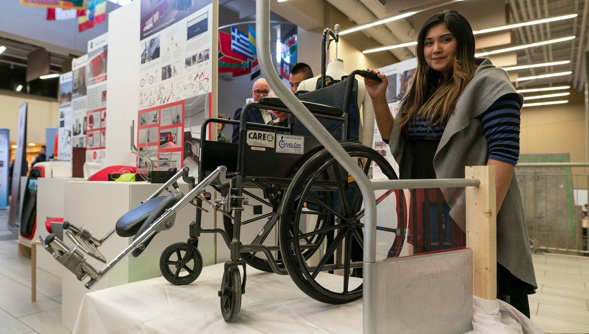 Amira Ashraf stands with a wheelchair.