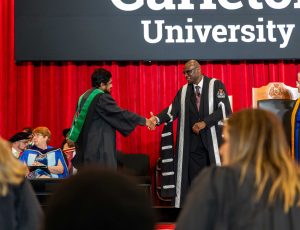 President Wisdom Tettey shakes a graduate's hand at convocation.