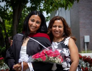A student and her supporter smile as they pose for a photo.