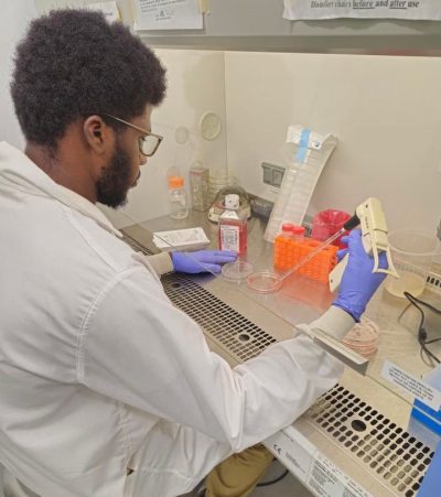 A man in a lab coat works in a lab