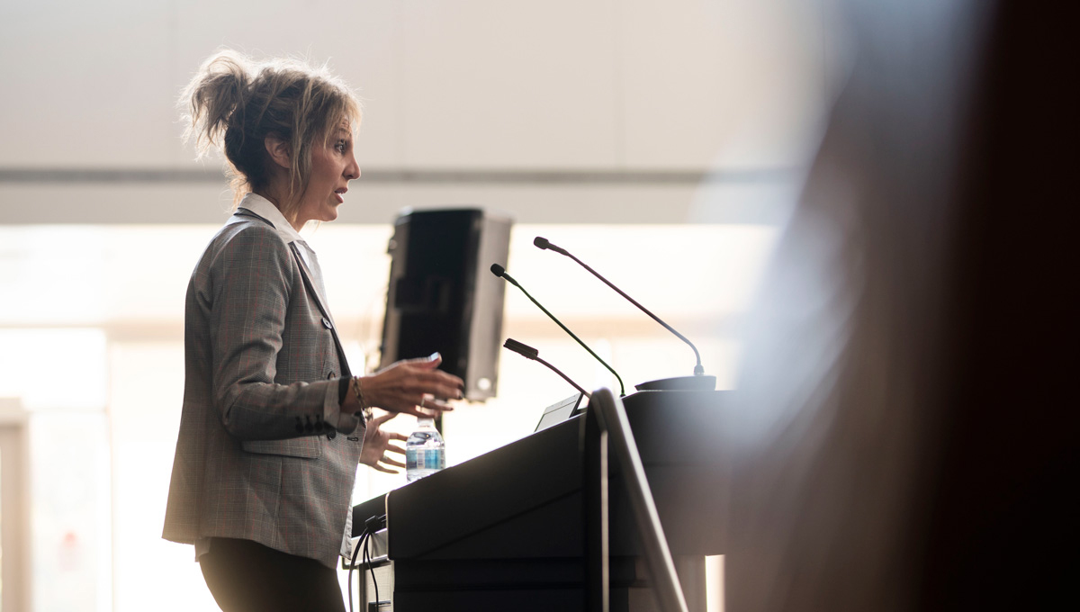 Prof. Joanna Pozzulo speaks at a podium during Psychology Mental Health Day.