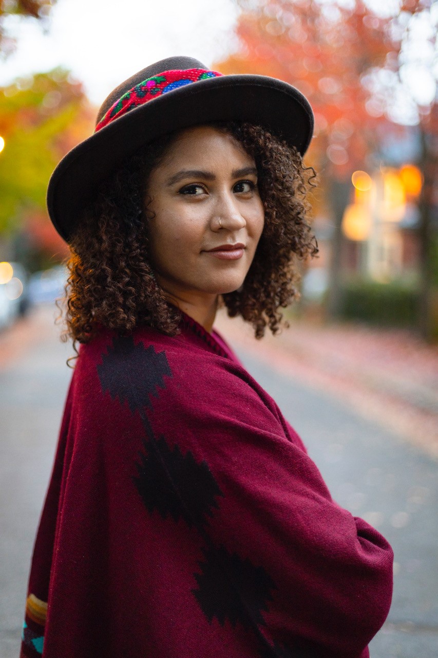 A young woman poses for the camera wearing a hat.