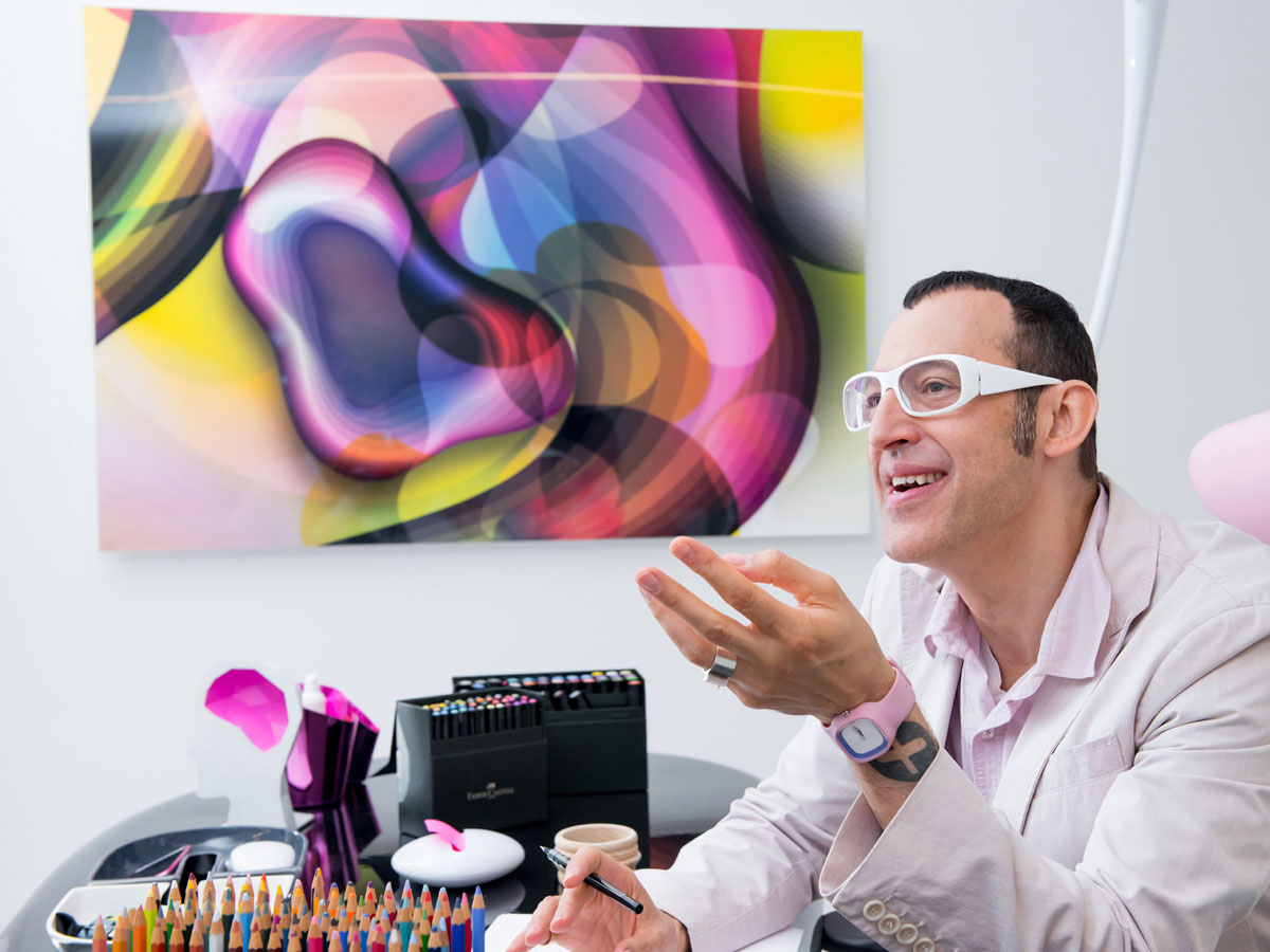 Karim Rashid in a studio setting surrounded by drawing tools.