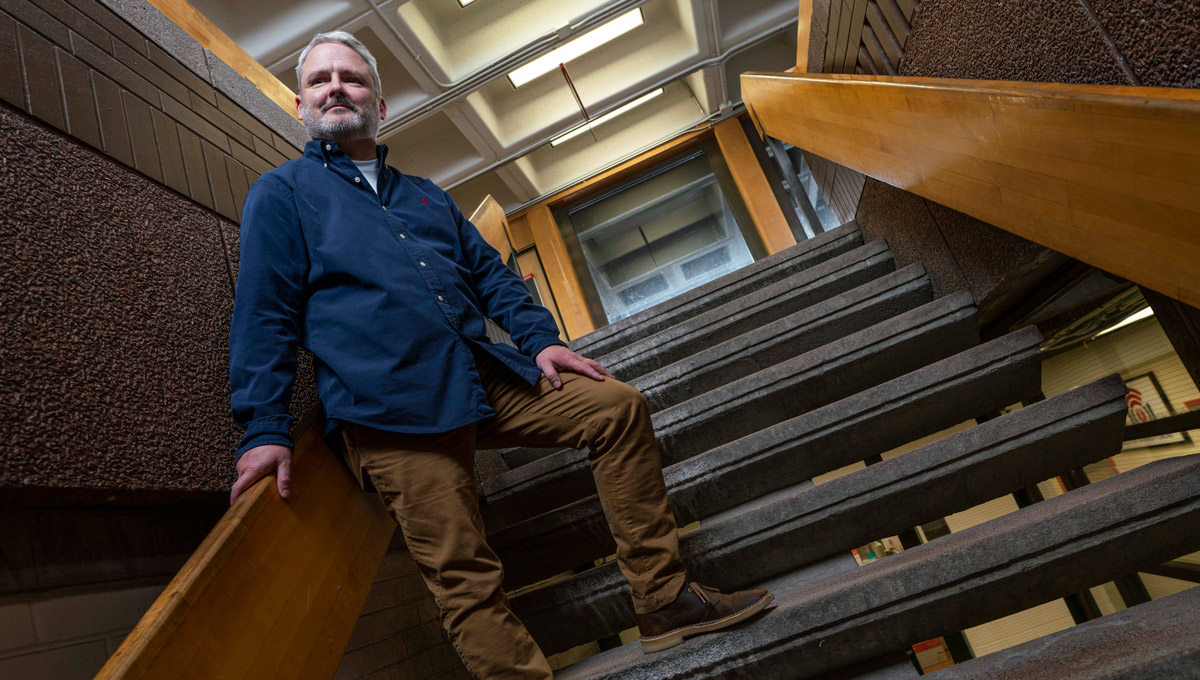 Discovery University instructor Matthew Sorley poses on a set of stairs.