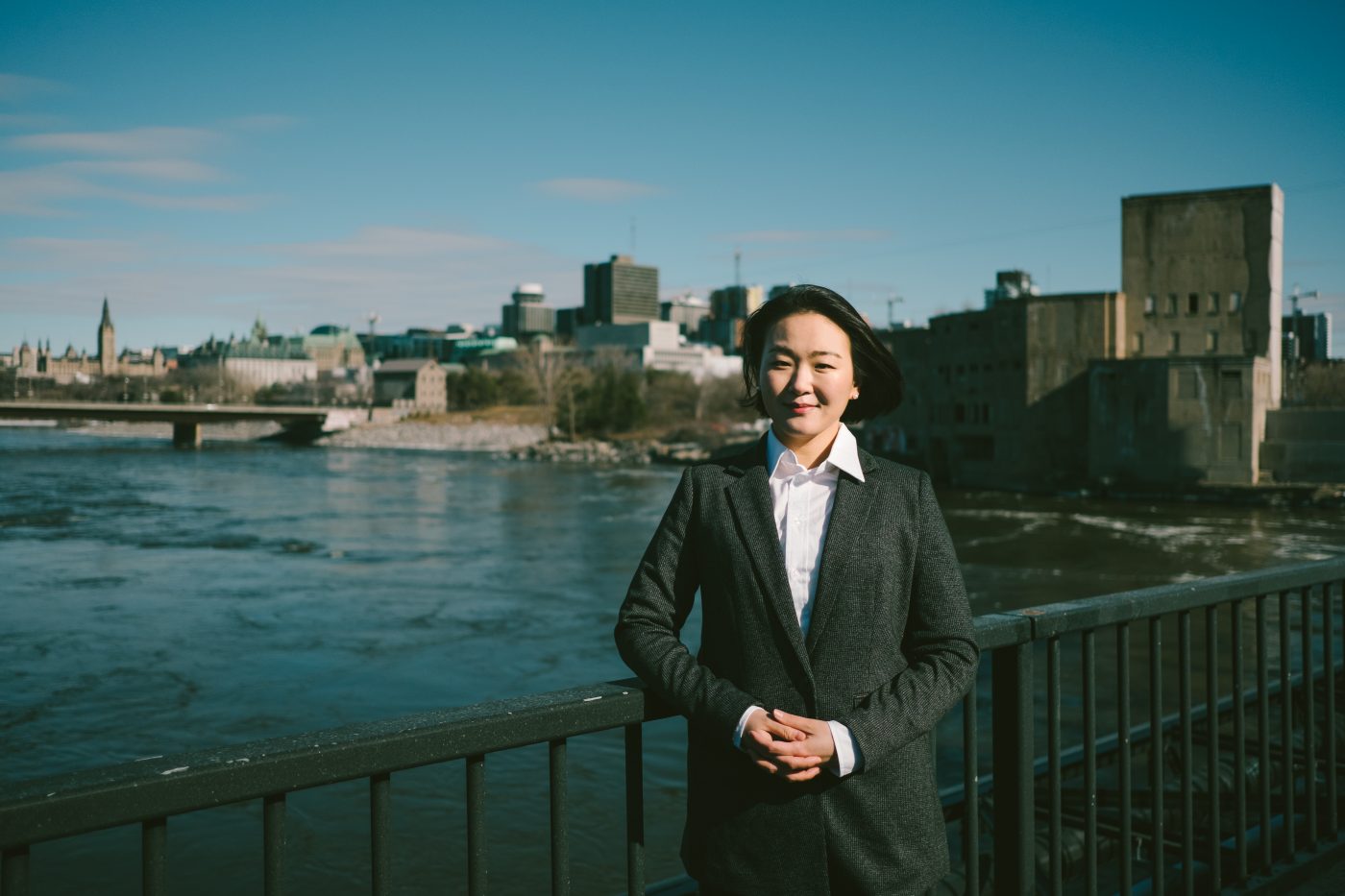 Prof. Yeowon Kim standing on bridge with Ottawa River and city infrastructure behind her
