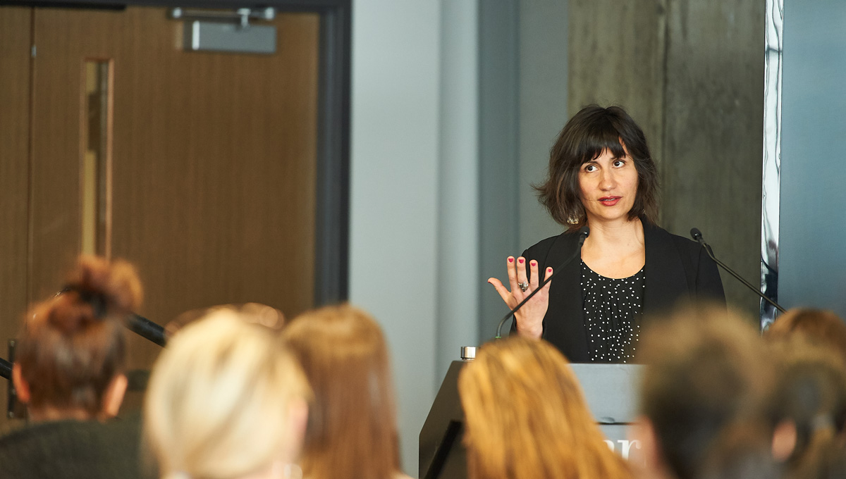 Prof. Sarah Everts speaks at a podium in front of a crowd.