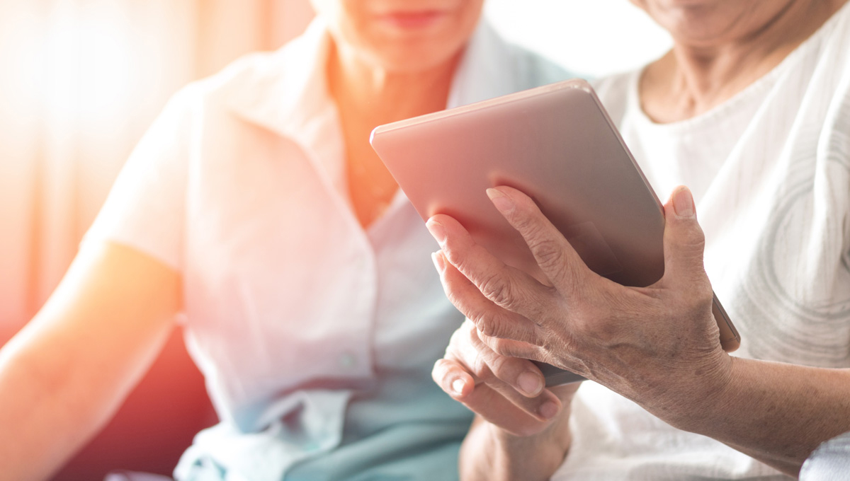 Two senior citizens use iPads.