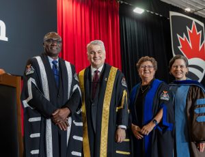 President Wisdom Tettey, Chancellor Nikita (Nik) Nanos, Board Chair Beth Creary and Senate Clerk Elinor Sloan pose for a photo on the convocation stage.