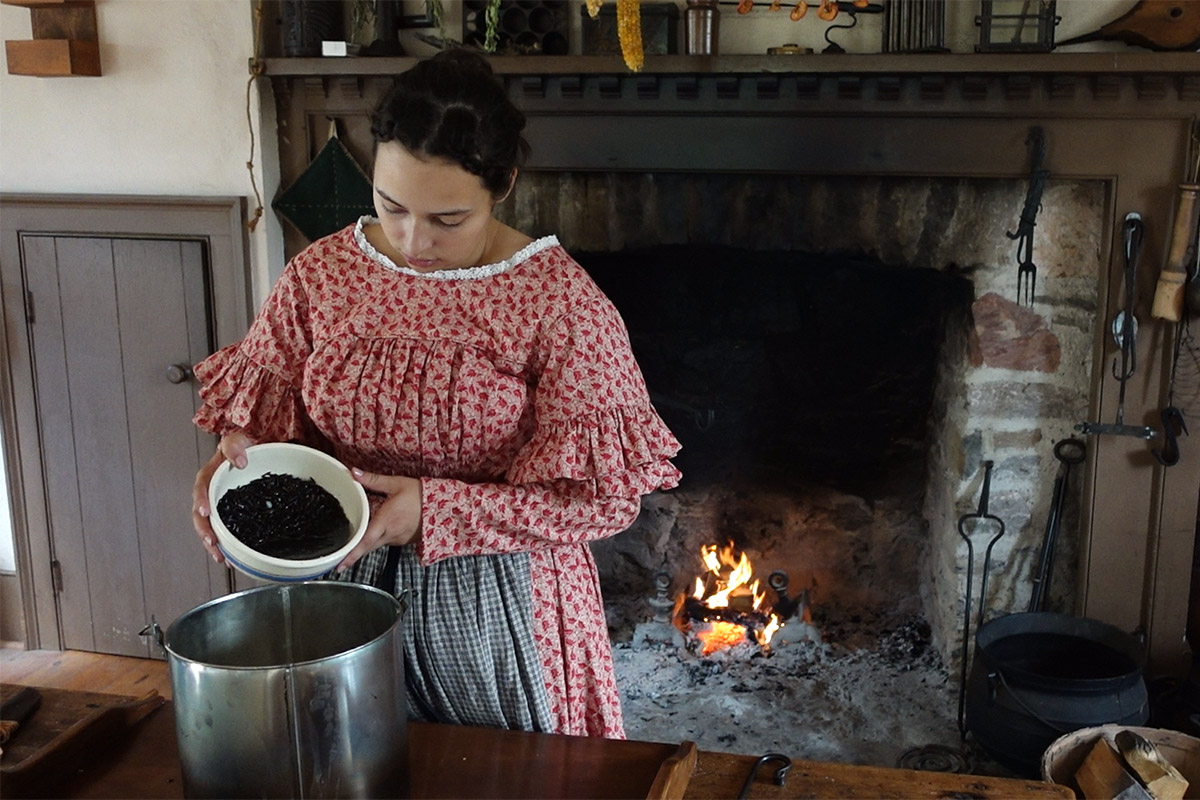 A woman pours an ingredient into a large bowl while cooking, an example of Canadian culinary history.
