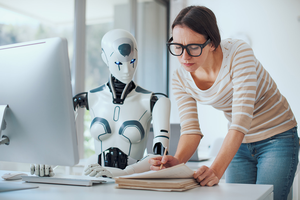 A woman overseeing the work of a robot.
