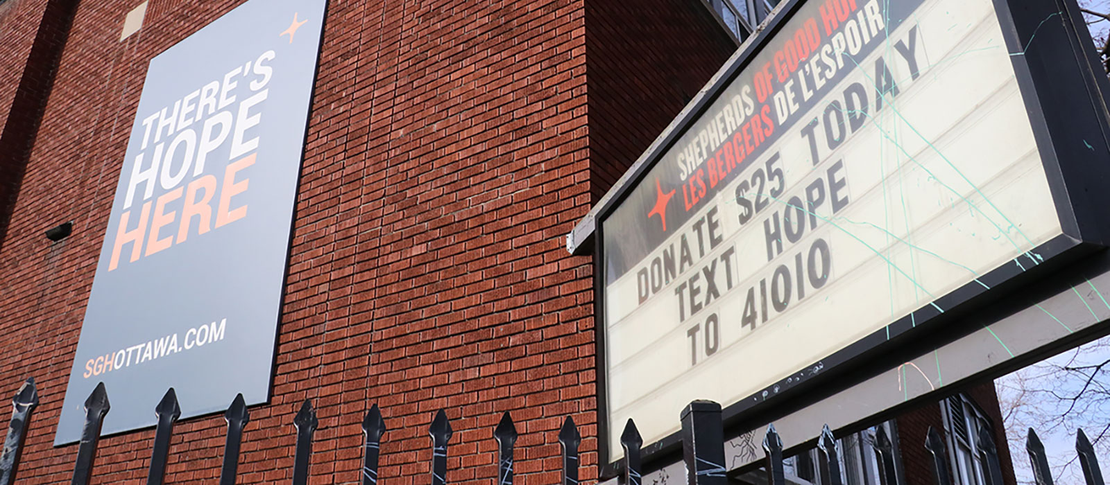 A sign on a brick wall which reads There Is Hope Here