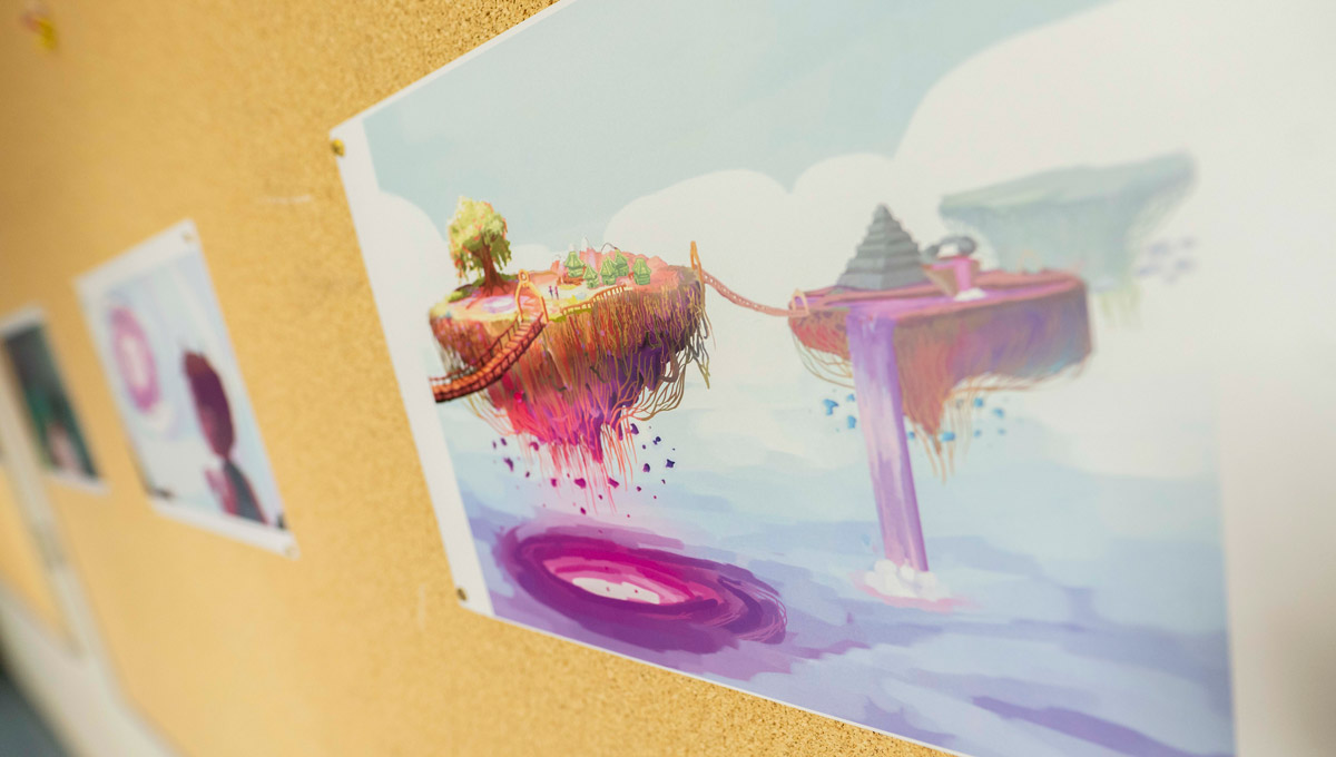 Artwork of a floating island from a videogame is posted on a corkboard.