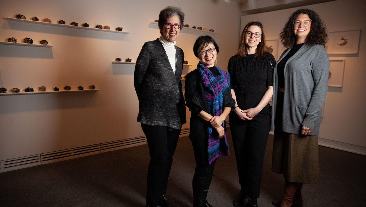 A group of women academics stand together in the Carleton University Art Gallery.