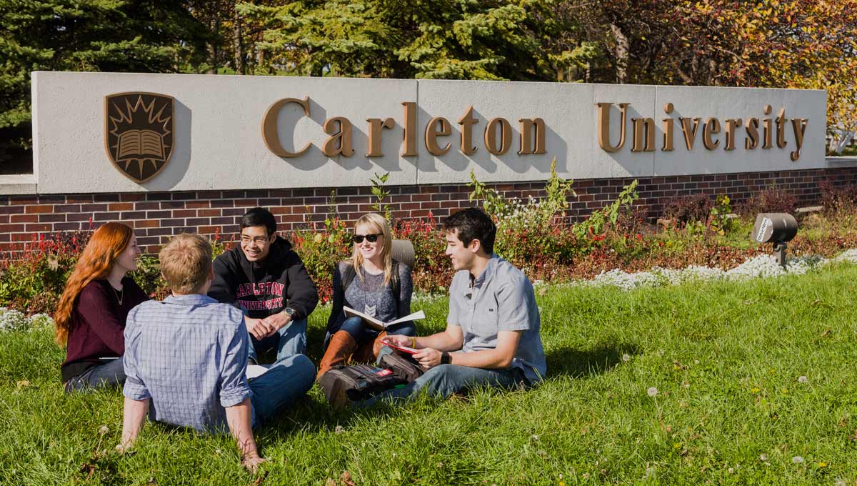 Students, who will benefit from new Carleton programs in 2016 - '17, sit in the grass in front of the Carleton sign at Bronson and Sunnyside.