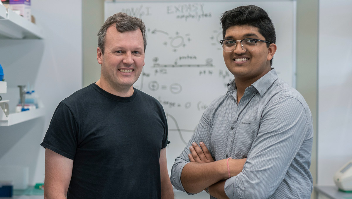 Prof. Bill Willmore and Bhavya Mohan pose in a lab during their science mentorship.