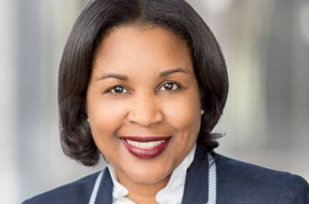 A professional headshot of a woman wearing a business suit.