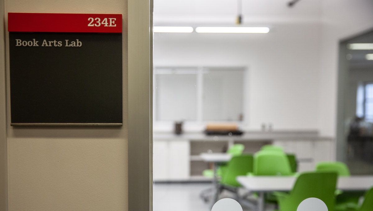 A sign for the Book Arts Lab hangs at its entrance.