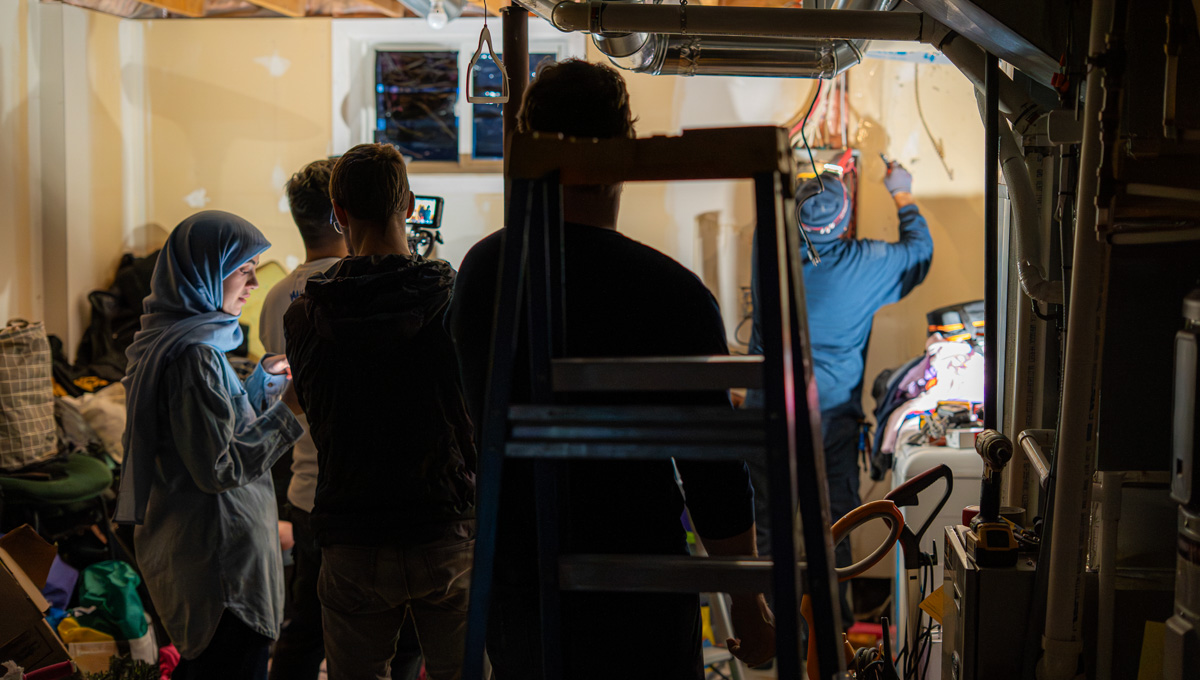 Researchers from Carleton University’s Centre for Advanced Building Envelope Research look on as energy efficiency technology is installed in a residential home..