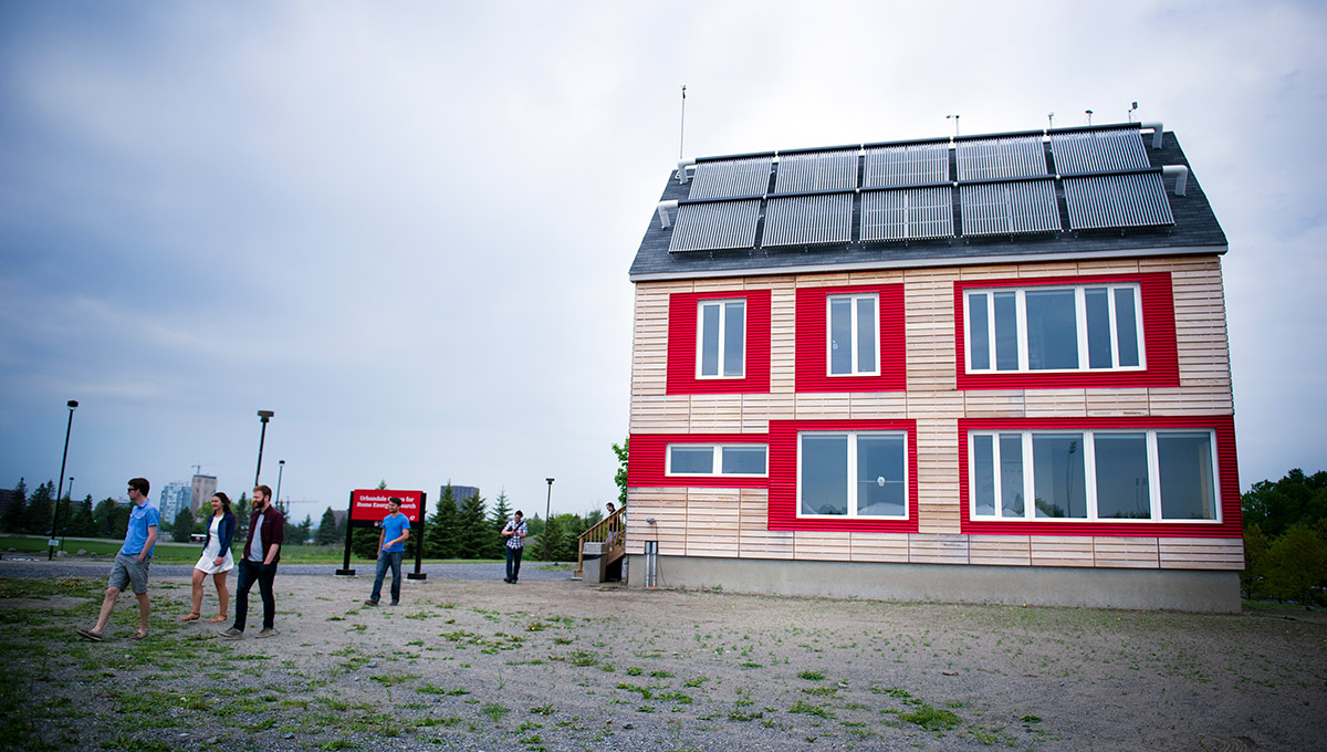 A photo of students walking outside of the Urbandale Centre for Home Energy Research located on the Carleton University campus.