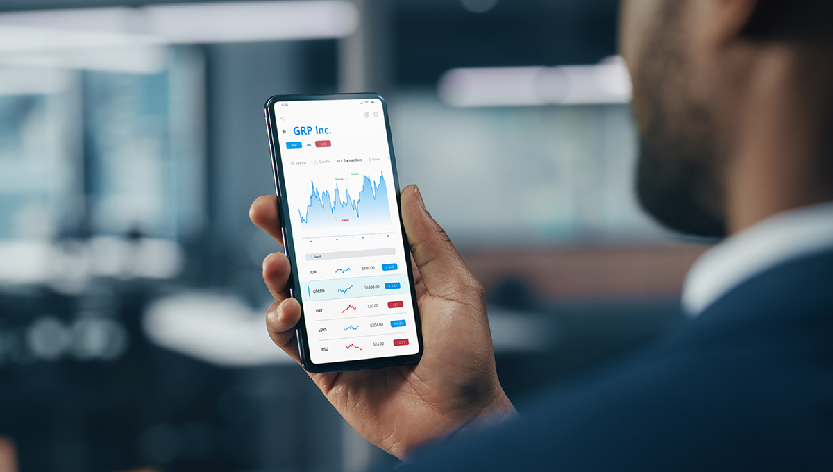 A man checks a stock price on a mobile phone.