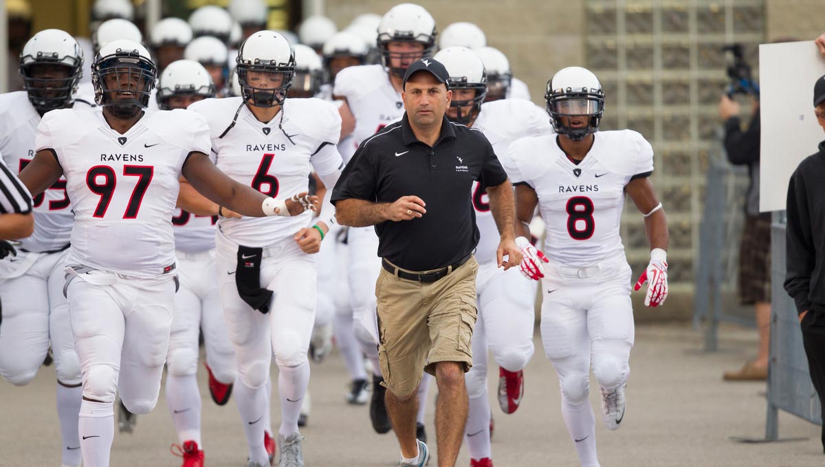 Carleton Ravens head coach Steve Sumarah leads the team onto the field before a game.