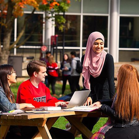 A group of Carleton University students working at a picnic table