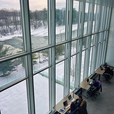 A from above view of students studying by a large glass window