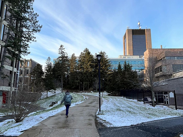 Carleton student walking on campus in winter