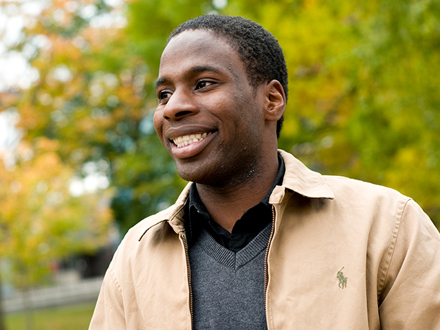A Carleton University student smiles while looking away from the camera