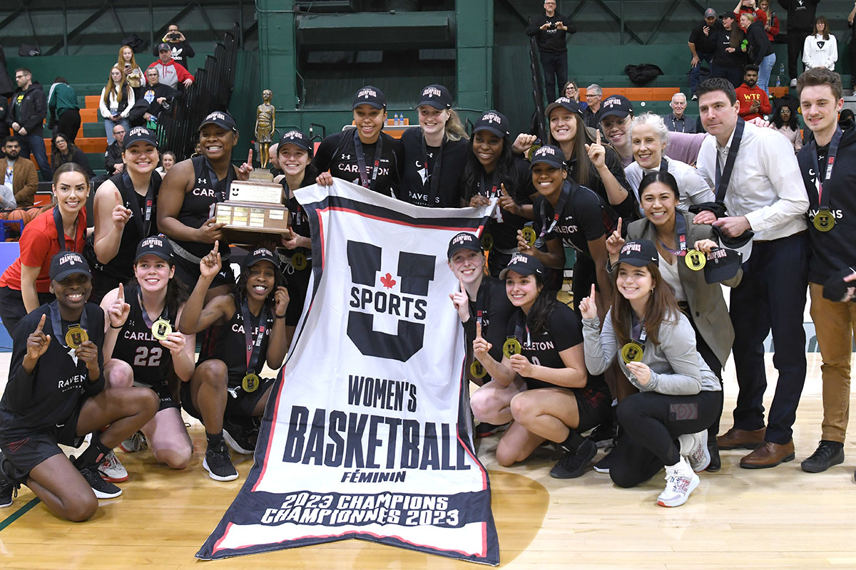 A championship winning women's basketball team poses for a team photo.
