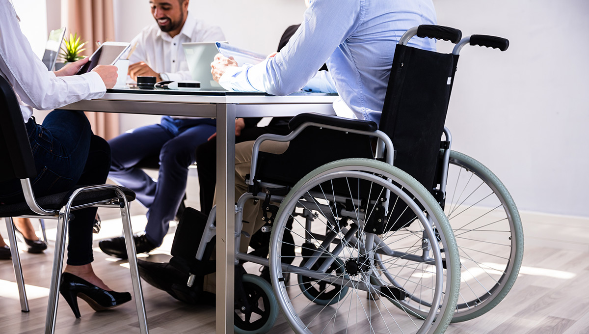 Businessman sitting in a meeting while using a wheelchair