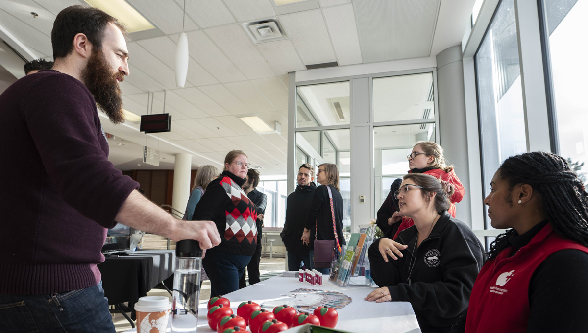 A student group composed of women speak to a male student during the event in the Tory lobby.