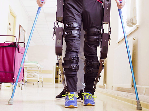 A person walking wearing an exoskeleton for assisted walking.