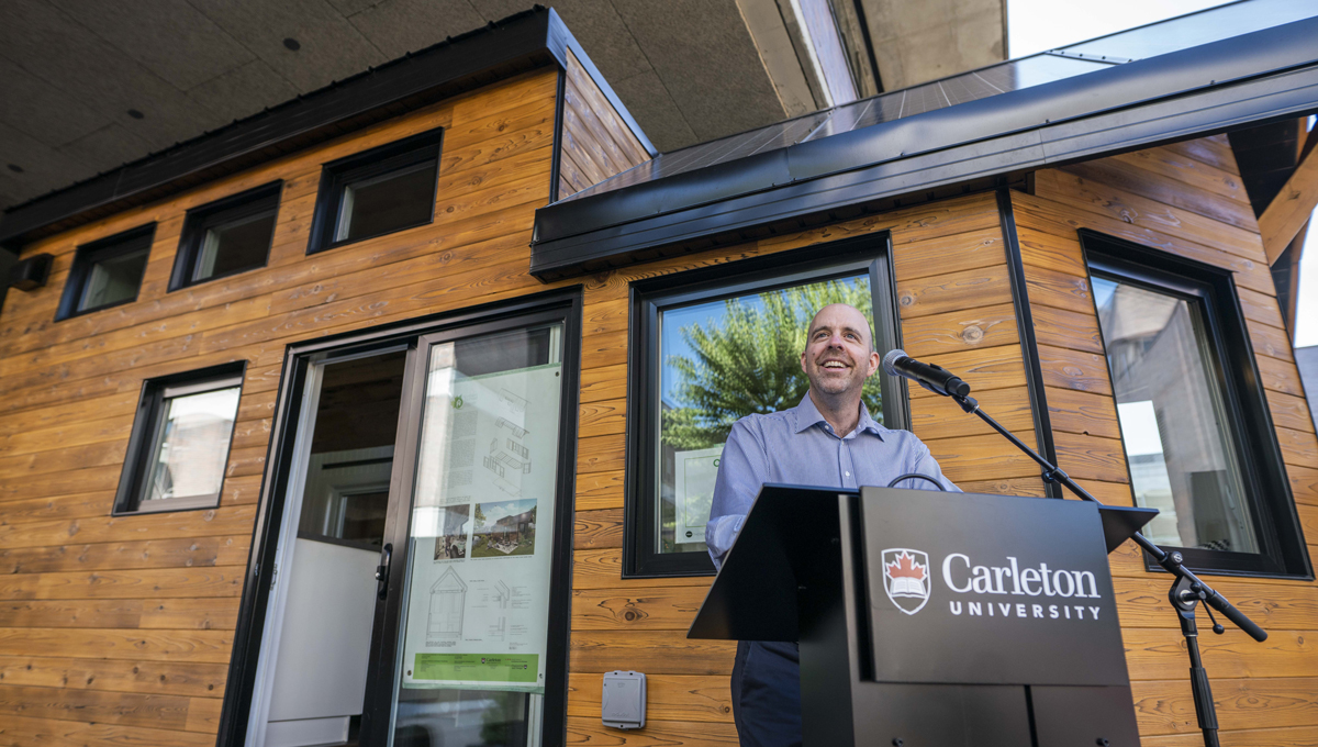 President Benoit-Antoine Bacon speaks at the opening of the Northern Nomad energy autonomous house, which was designed and built by students.