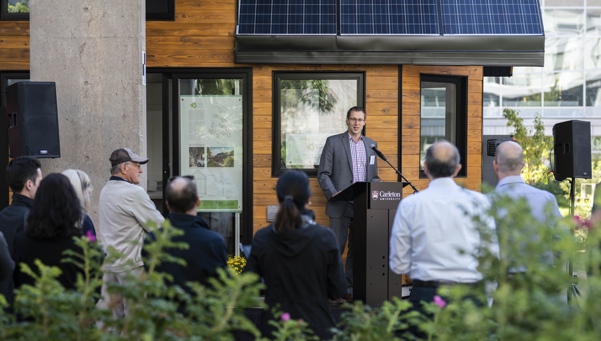 Professor Scott Bucking speaks at the opening of the Northern Nomad energy autonomous house, which was designed and built by students.