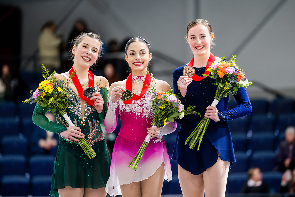 Three figure skating medalists posing for a photo