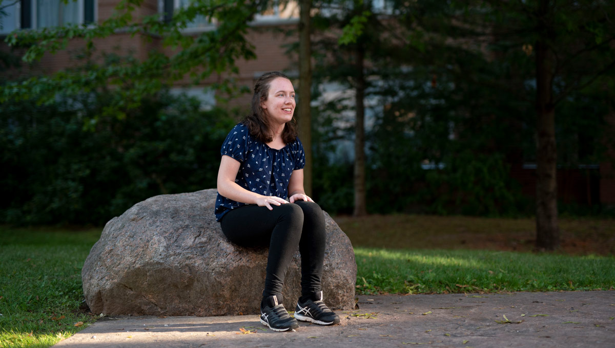 Hannah MacLellan sits outside in Carleton's Residence Quad. Hannah has accomplished a lot at the age of 19 and she’s just getting started in her life-long quest for disability rights.