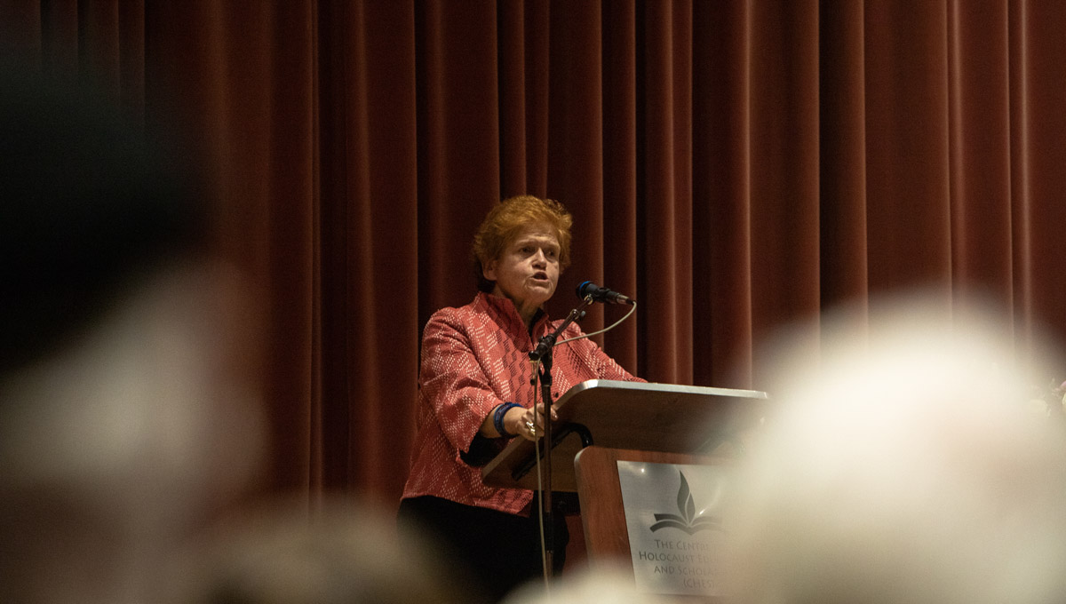 Historian Deborah Lipstadt speaks into a microphone while the audience listens.
