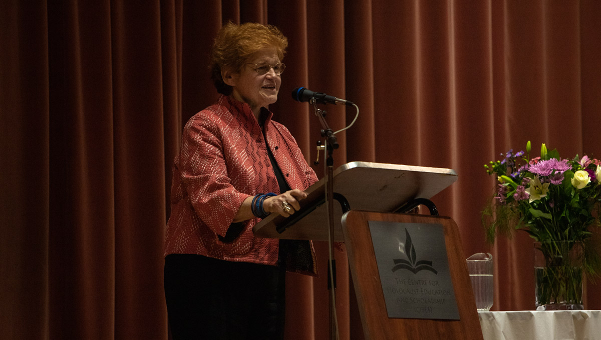 Historian Deborah Lipstadt speaks at a podium while the audience listens.