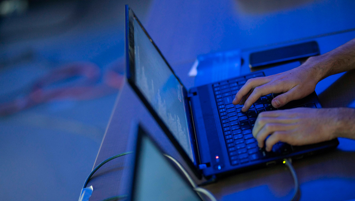 An competitor types on a laptop during the iHack event.