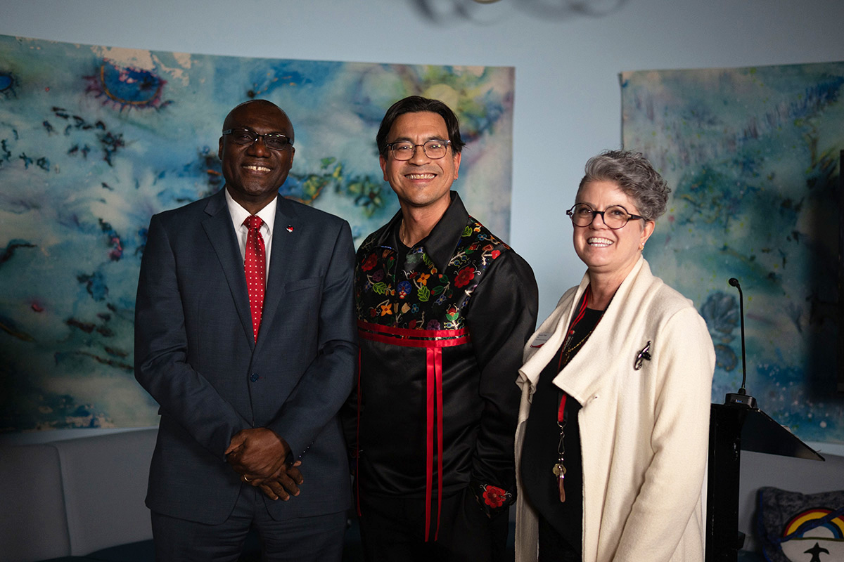 Three people posing for a group photo at an event celebrating Indigenous journalists.